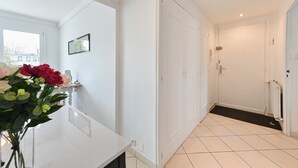 A hallway with white walls, a tiled floor, and a door leading to a bathroom. - Le Boileau - Apartment for 4 people, parking and balcony, CLOSE to the Lake (Annecy)