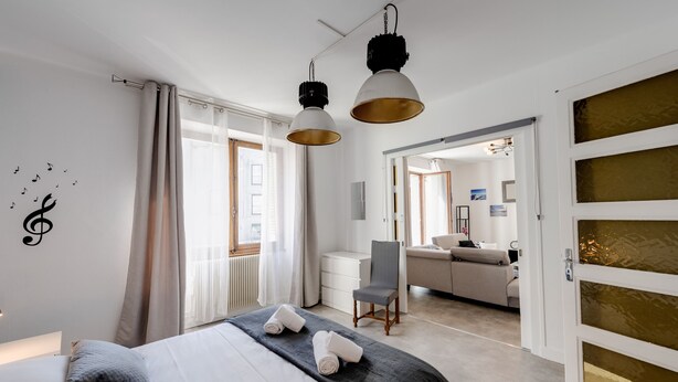 A modern hotel room with a neatly made bed, a desk, and a comfortable seating area.