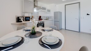 A modern kitchen with white cabinets, a built-in oven, and a refrigerator. - La Cantonade - Nice T2 with garage for 4 people near Beach (Annecy)