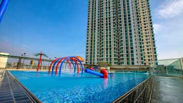 Una piscina al aire libre, sillones reclinables de piscina