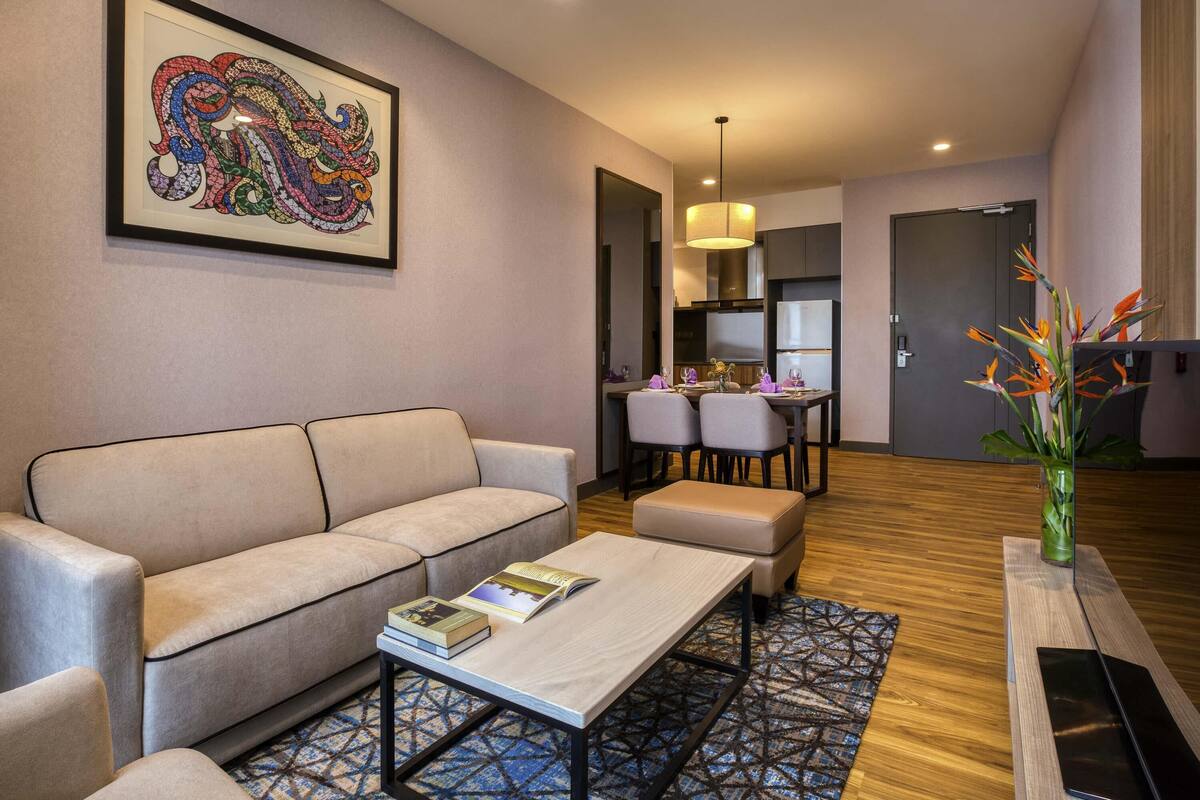 Un salon moderne comprenant un canapé, une table basse et un coin repas avec des chaises et une table.