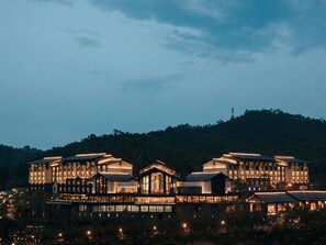 A large, multi-story hotel with a modern architectural design, featuring numerous windows and a prominent central building. - Pullman Yuxi Falcon (Yuxi)