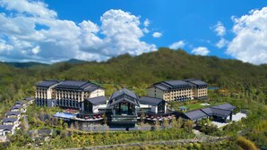 A modern hotel complex with multiple buildings, a central courtyard, and surrounding greenery. - Pullman Yuxi Falcon (Yuxi)