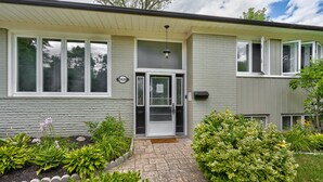 A single-story house with a front door, a mailbox, and a number sign.