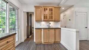 A kitchen with wooden cabinets, a granite countertop, and a view of the outdoors.