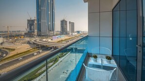 Un balcon offrant une vue dégagée sur le paysage urbain, avec de grands immeubles et une autoroute.
