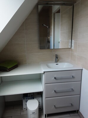 A modern bathroom with a white sink, a mirror above it, and a towel rack.