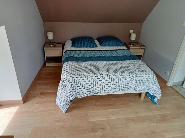 A bedroom with a bed, two bedside tables, and a nightstand.