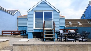 A small, single-story building with a blue exterior and a white-framed window. - Beach Side House in Beautiful Borth (Borth)