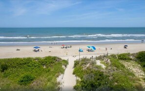 A beach with umbrellas and people. - Oceanside 7BR House with Private Pool and Hot Tub (Corolla)
