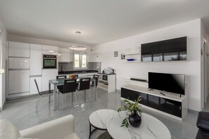 Enjoy a spacious living area with a dining space, kitchen, and flat-screen TV.