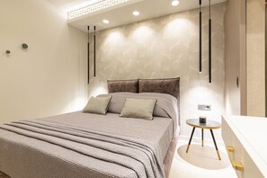 A modern bedroom with a large bed, a bedside table, and a small round table with a cup.