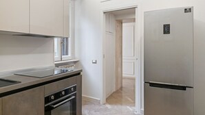 Een moderne keuken met roestvrijstalen apparatuur, een inbouwoven en een koelkast.