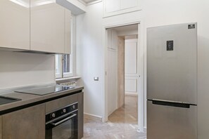 A modern kitchen with stainless steel appliances, a built-in oven, and a refrigerator.