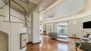 Une pièce spacieuse dotée d’une grande fenêtre, d’une cheminée et d’un canapé moderne.