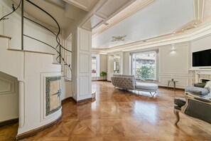 Une pièce spacieuse dotée d’une grande fenêtre, d’une cheminée et d’un canapé moderne.