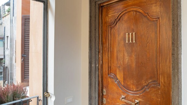 A wooden door with the number 'III' and a brass handle.