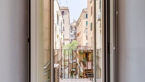 Un estrecho callejón flanqueado por edificios, un pequeño patio y una reja.