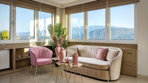 Ein modernes Wohnzimmer mit einem beigen Sofa, einem pinkfarbenen Sessel und einem runden Couchtisch.