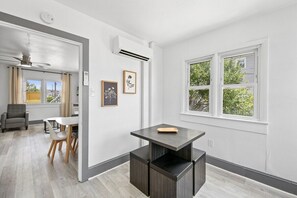 A modern kitchen with a dark countertop, a ceiling fan, and a window with a view of trees. - Shorehaven 1- Updated and Stylish 2 bedroom 14 St! (Ocean City)