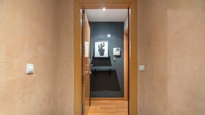 A hallway with wooden flooring, a door with a handle, and a wall-mounted phone. - Eixample 2 bedroom with private terrace (Barcelona)