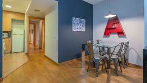 Une cuisine moderne équipée d’un four à micro-ondes, d’un réfrigérateur et d’un coin repas avec une table et des chaises.