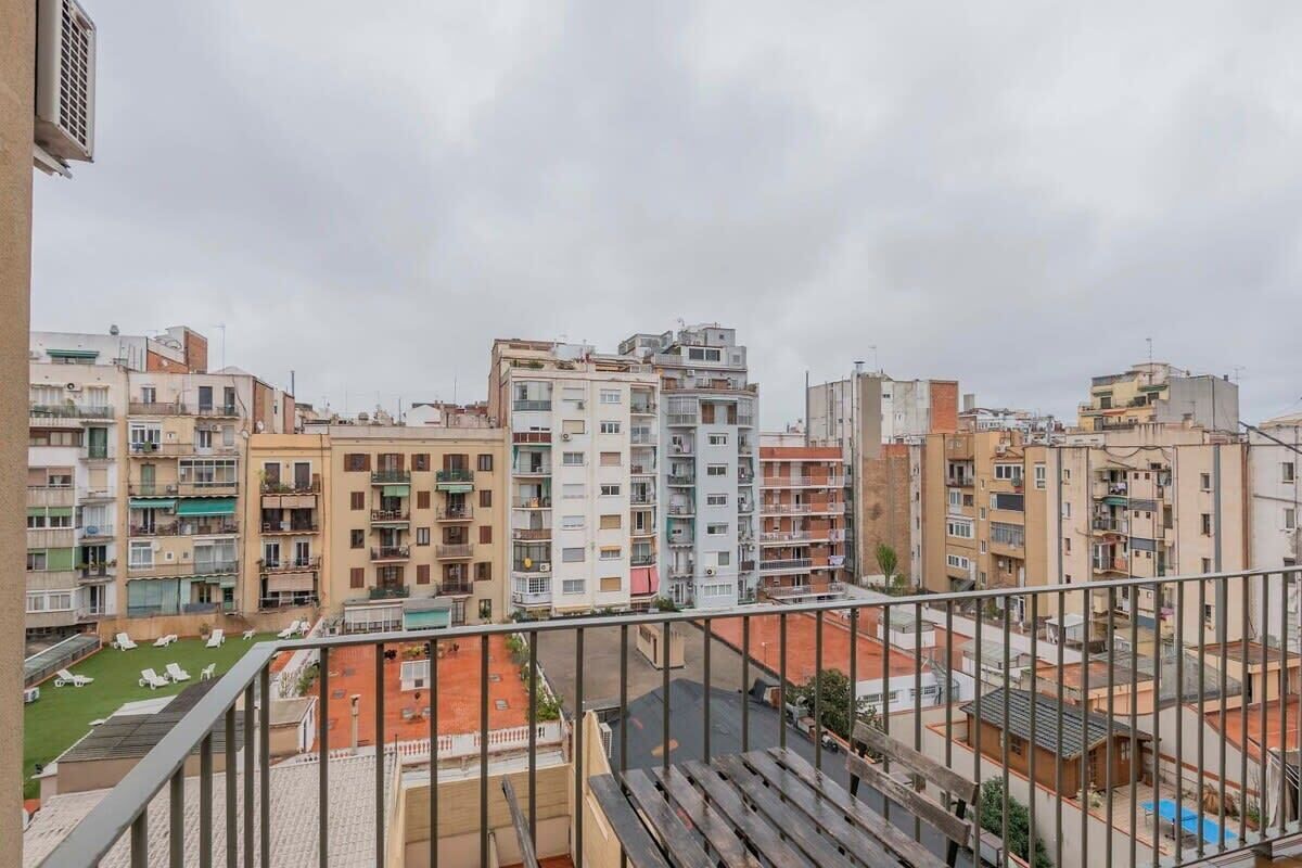 Un quartiere residenziale con edifici a più piani, un balcone ben visibile e un piccolo spazio verde.