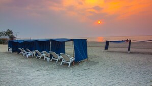A beach with lounge chairs and a covered area, likely for sunbathing or relaxation. - Reserva Del Mar 624 (Santa Marta)