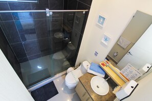 A bathroom with a glass-enclosed shower, a toilet, and a sink with a soap dispenser. - Reserva Del Mar 624 (Santa Marta)