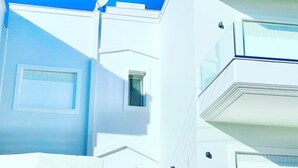 A modern building with white exterior walls, a satellite dish, and a small window. - 2 Coastal villas 5 min. From beach. Panoramic view of sea and sunset (Καλύβια Θορικου)