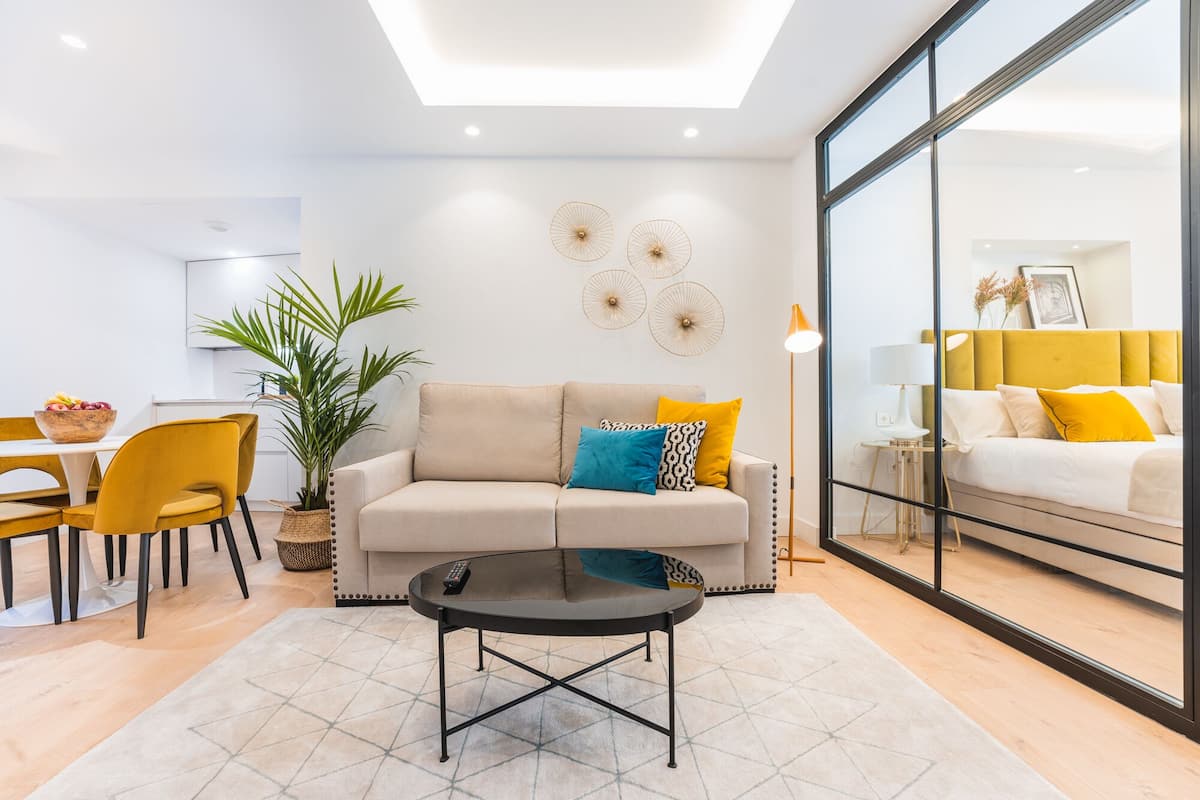 Uma sala de estar moderna com sofá, mesa de centro e área de jantar.