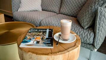 A magazine titled "ONE DESIGN" on a wooden table with a cup of coffee.
