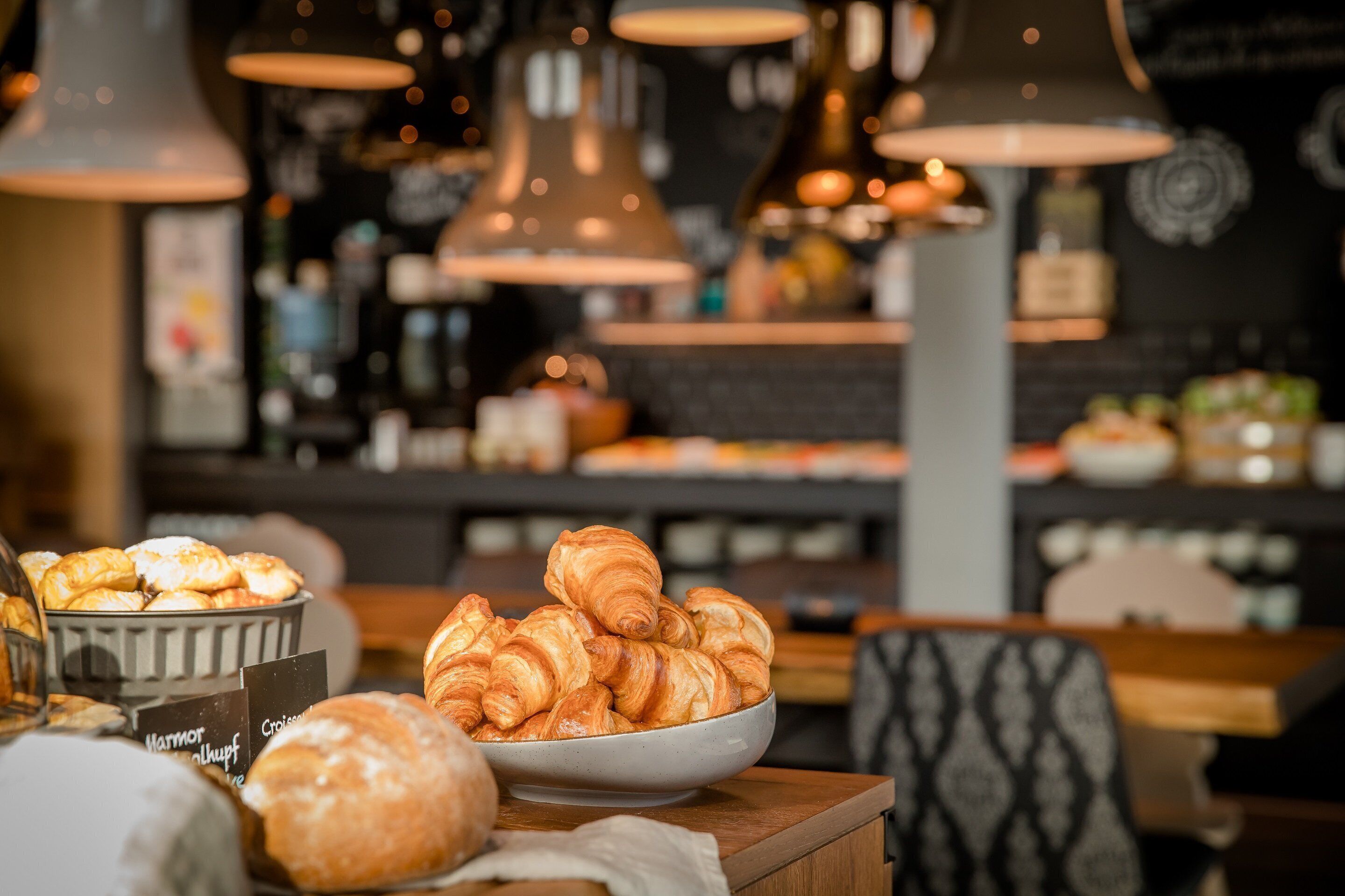 A bakery display with croissants and other baked goods.