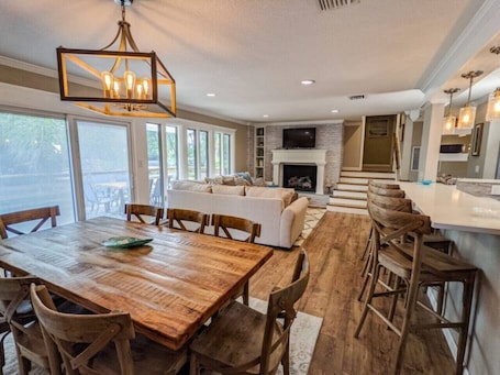 A spacious kitchen with a dining area, wooden furniture, and a fireplace.