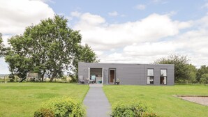 A modern house with a pathway leading to the entrance, surrounded by greenery and a large tree. - Moss of Bourach (Aberlour)