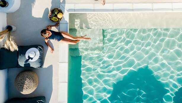 Un espace piscine aménagé sur le toit, avec deux chaises longues, un hamac et une petite table sur laquelle est posée une boisson.