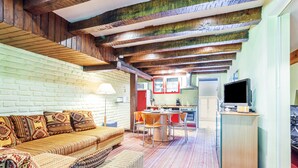 A cozy living room with a sofa, a dining table, and a kitchen area with appliances. - Surfinia - piscine partagée - proche Europa Park (Hessenheim)