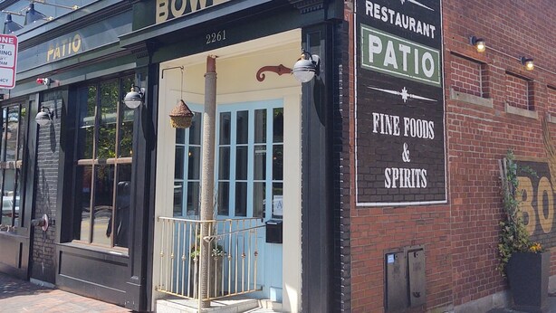 Un edificio con un letrero que dice 'The Bowery Bar Restaurant Patio Fine Foods & Spirits'.