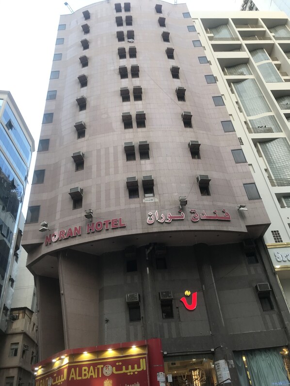 A hotel with multiple floors, balconies, and a sign indicating it is the Noran Hotel.