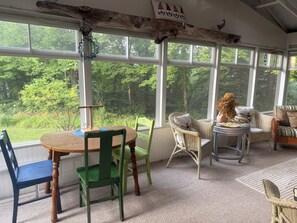 A room with a large window, a round table, and chairs.