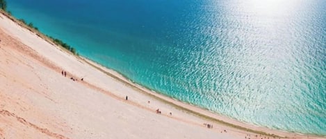 Una playa con una vista despejada del océano y una suave pendiente arenosa.