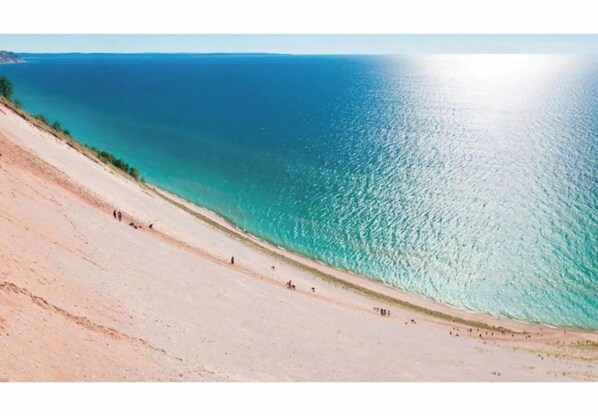 A beach with a clear view of the ocean and a sandy slope.