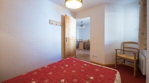 Cozy retreat with a comfortable bed, wooden chair, and dining area.