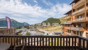 A balcony with a view of a mountainous town, wooden buildings, and a flag. - Apt 8 ppl, balcony, near the ski runs, parking (Orcières)