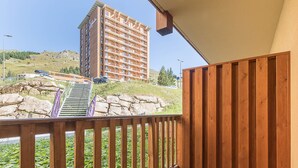 A balcony with a wooden railing overlooking a parking area and a multi-story building. - Bright apt 4 ppl near the ski runs, balcony (Orcières)