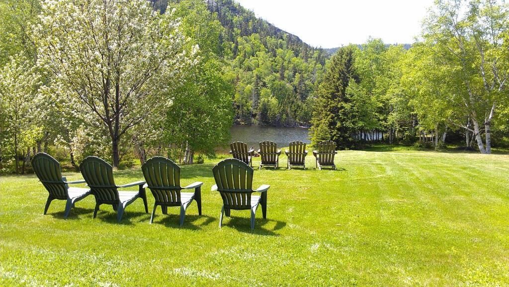 A grassy area with several Adirondack chairs arranged in a semi-circle.