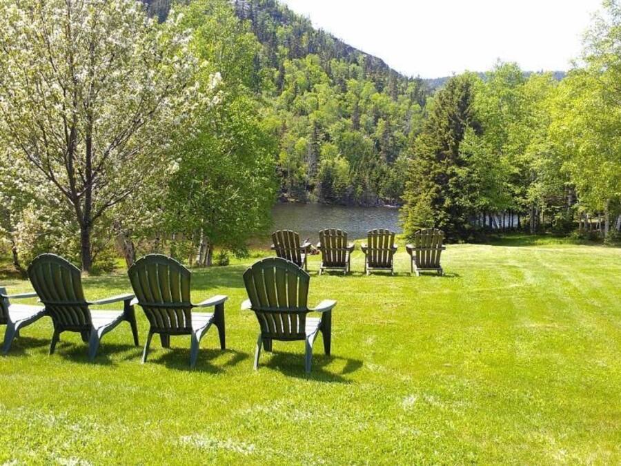A grassy area with several Adirondack chairs arranged in a semi-circle.