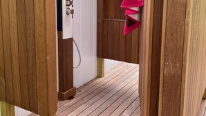 A wooden deck leading to a spa area with a shower and a towel rack. - Newly renovated Modern East Hampton Home / September available (East Hampton)
