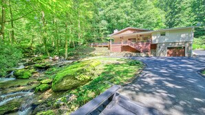 A house with a stone foundation, a covered porch, and a stone garage door.