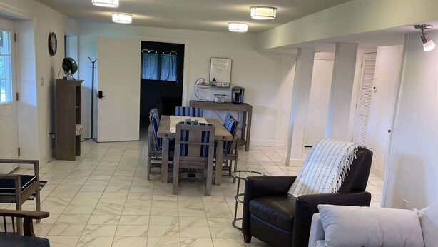 Un salon spacieux comprenant un coin repas, un canapé, une table basse et un fauteuil.